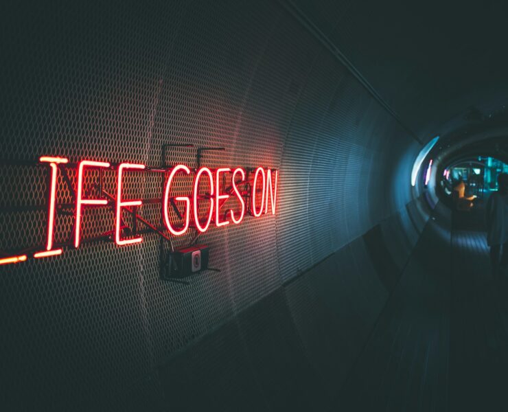 a neon sign that reads life goes on