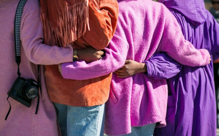 four person holding each others waist at daytime