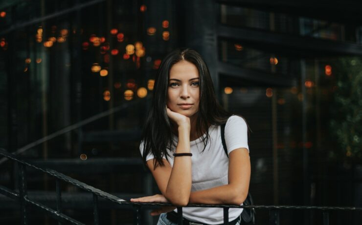 woman leaning on black handrail