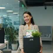 Woman carrying box of belongings leaving office