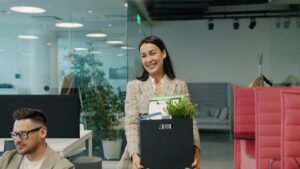 Woman carrying box of belongings leaving office