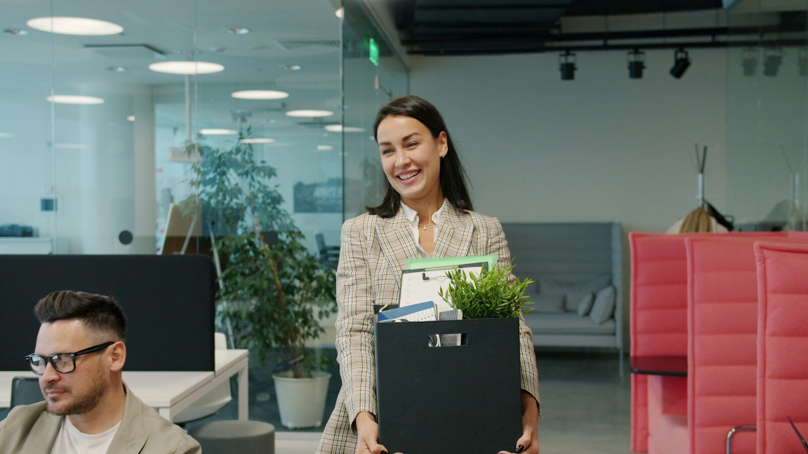 Woman carrying box of belongings leaving office